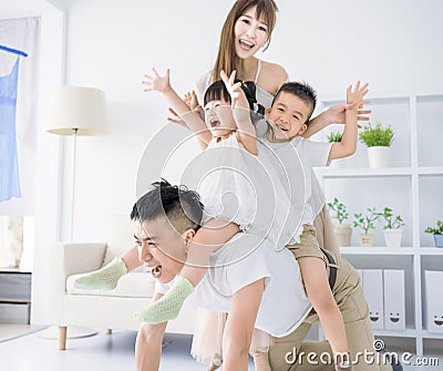 Father giving piggyback to excited child and playing at home Stock Photo