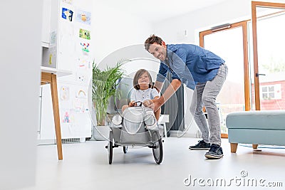 Father helping his son to drive a toy peddle car Stock Photo