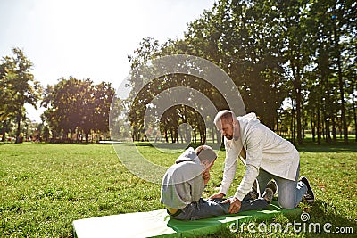 Father helping son with cerebral palsy crunching Stock Photo