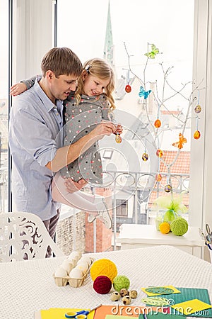 Father and her daughter painting and decorating easter eggs. Stock Photo