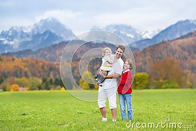 Father with his kids in mountain covered snow Stock Photo
