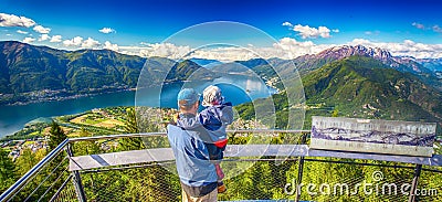 Father and his son enjoying the view to Locarno city and Lago Maggiore from Cardada mountain, Swiss Alps, Ticino, Switzerland Editorial Stock Photo