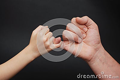 Father holding Daughter hand. Friendly parental relationships. Black Background. Stock Photo