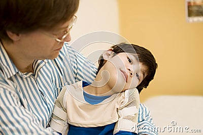 Father holding disabled son at hospital Stock Photo