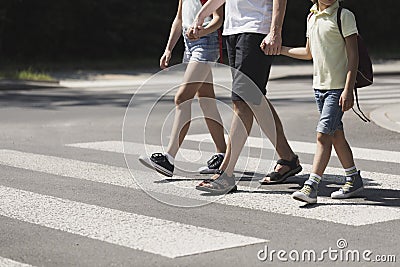 Father holding hands with his kids while on pedestrian crossing Stock Photo