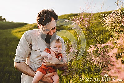 Father holding infant baby walking outdoors family lifestyle Stock Photo