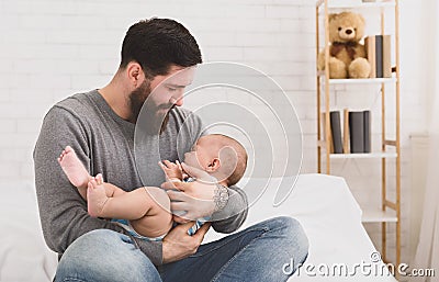 Father holding and soothing crying newborn baby in his arms Stock Photo
