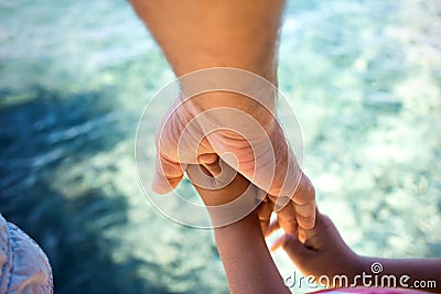 A father holds the hand of His son to the seashore Stock Photo