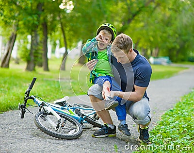 Father inspects the injured child had fallen off the bike Stock Photo