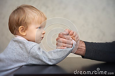 Father and kid arm wrestling competition Stock Photo