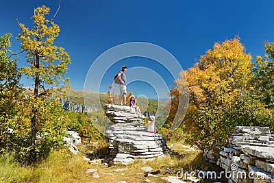 Father and kids exploring Stone forest, natural rock formation, created by multiple layers of stone, located near Monodendri Stock Photo