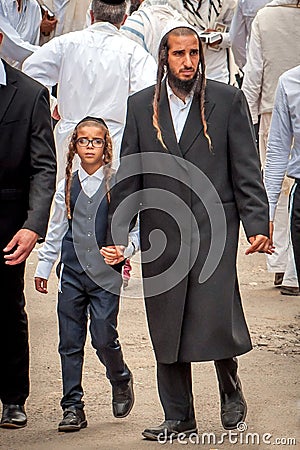 The father leads the son by the hand. The Hasidim pilgrims. Rosh Hashanah, Jewish New Year. Editorial Stock Photo