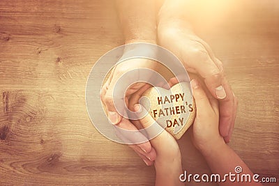 Father and little child holding together wooden heart. Happy father`s day concept Stock Photo