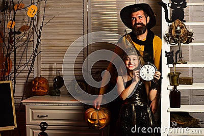 Father and little girl with alarm clock wait for halloween coming soon. Little girl and father dressed up for halloween Stock Photo