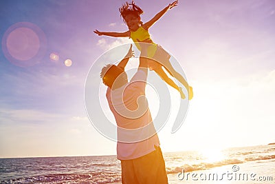 Father and little girl playing on the beach Stock Photo