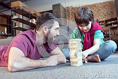 Father looking at son playing jenga game Stock Photo