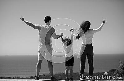 Father mother and child on the summer beach at the sunset time. Friendly family. Freedom carefree people concept. Stock Photo