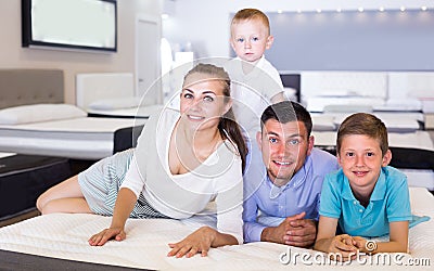 Father with mother and children are testing quality of mattress Stock Photo