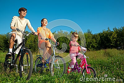 Father, mum and daughter go for drive on bicycles Stock Photo