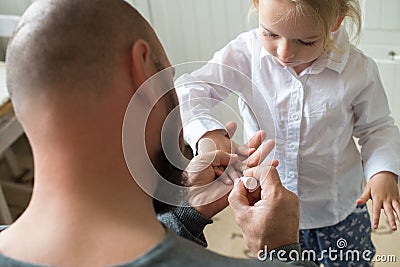 Father painting daughters finger nails Stock Photo