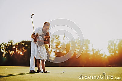 Father Playing Golf with Little Daughter on Field. Stock Photo