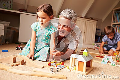 Father playing with kids and toys in an attic playroom Stock Photo