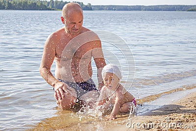 Father plays with his daughter in the lake in summer, happy family on summer vacation Stock Photo