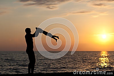 Father plays with son against a sunset Stock Photo