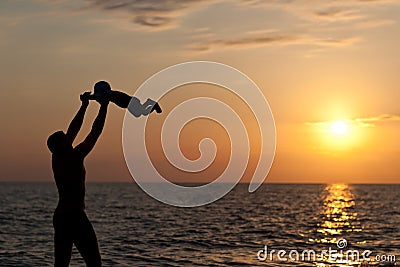 Father plays with son against a sunset Stock Photo