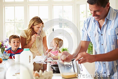 Father Preparing Family Breakfast In Kitchen Stock Photo