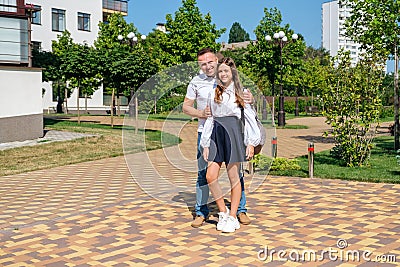 Father proudly hugs his schoolgirl daughter before she goes to school. Stock Photo