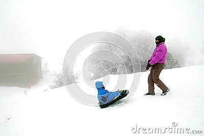 Father pulls a child on a sled. Dad and son having fun Editorial Stock Photo