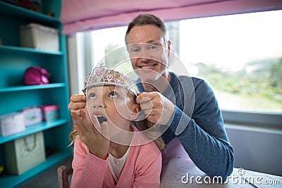 Father putting a tiera on daughters head Stock Photo