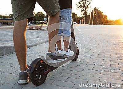 The father riding the electric scooter with his son Stock Photo