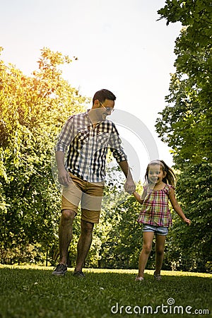 Father running in the meadow with daughter. Stock Photo