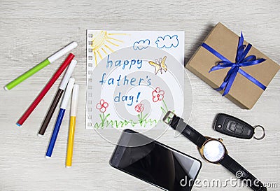 Father`s day. Children`s drawing and gift next to men`s accessories. Composition happy father`s day Stock Photo