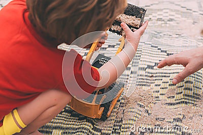 Father`s day. Dad and son. Little son plays toys with dad on the beach with sand. Stock Photo