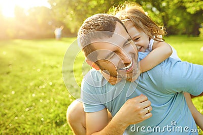 Father`s day. Father plays with his daughter in the summer park. Stock Photo