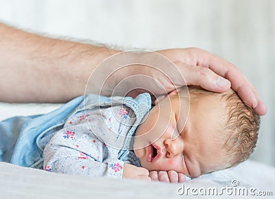 Father`s hand stroking a newborn baby Stock Photo