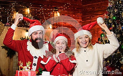 Father Santa claus costume with family celebrating christmas. Lovely daughter with parents wearing Santa hat. Gifts from Stock Photo