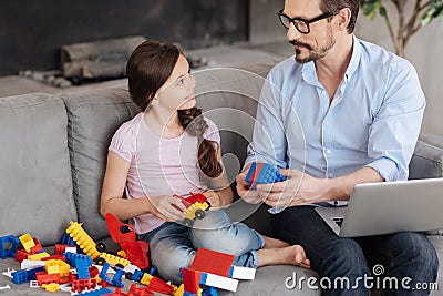 Father showing how two pieces of erector set match Stock Photo