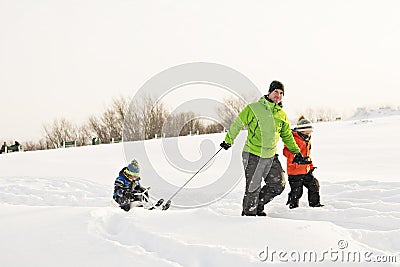 A cool Father drag his boy in sled Stock Photo