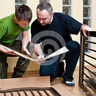 Father and son assemble crib Stock Photo