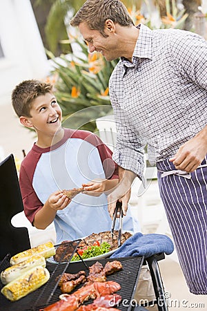 Father And Son Barbequing Stock Photo