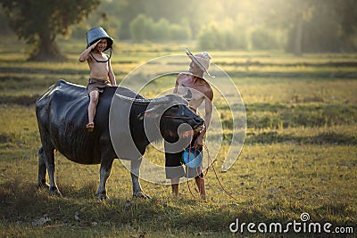 Father and son with a buffalo this lifestyle Thai people in Countryside Thailand. Stock Photo