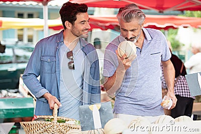 Father and son buying melon in outdoor market Stock Photo