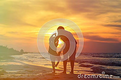 Father and son doing yoga at sunset sea Stock Photo