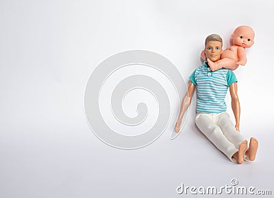 Father and son, dolls on a white background, father holds son in his arms, feeds his son. Caring for the family Stock Photo