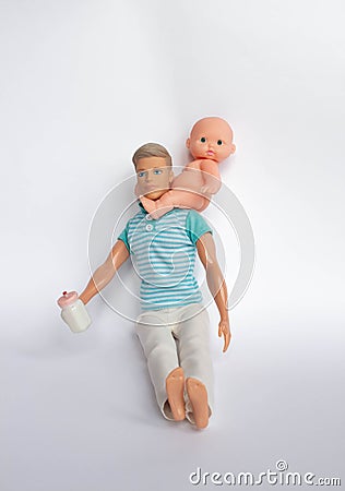 Father and son, dolls on a white background, father holds son in his arms, feeds his son. Caring for the family Stock Photo