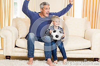 Father and son exulting on the sofa Stock Photo